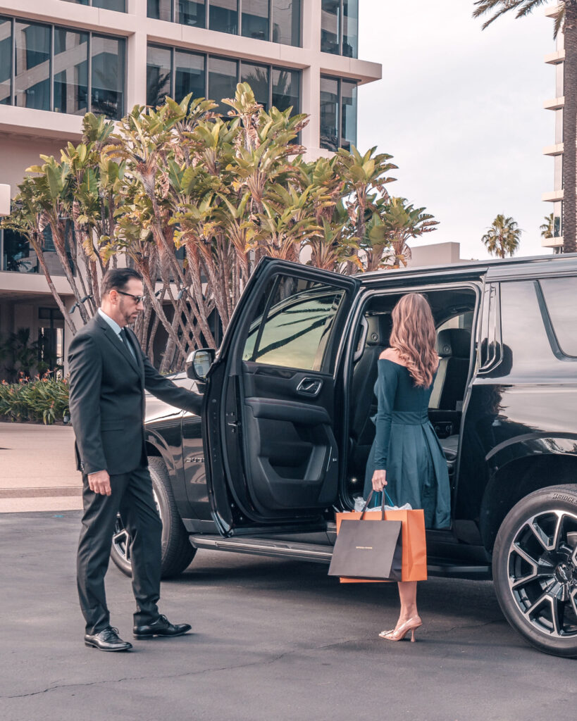 image of owner of black car Newport LLC opening the door for a passenger